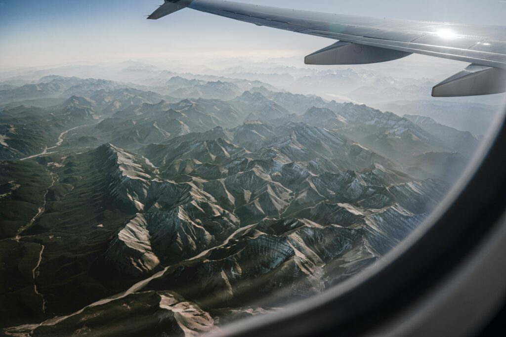 an airplane wing over a mountain range